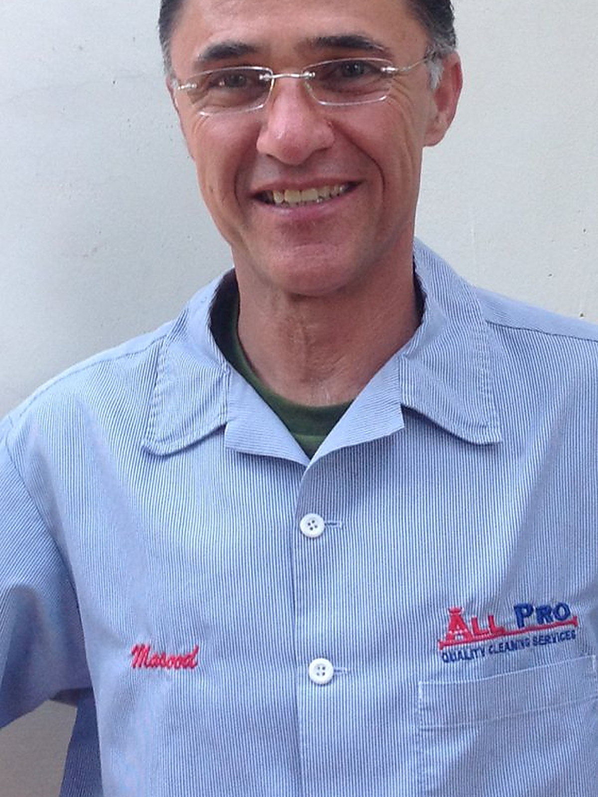 Masood Amirkhani in a pale blue work shirt with his name and the company logo stitched on it
